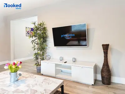 a living room with a tv on a wall at HOUSE WITH POOL and BBQ, 12 MIN to the BEACH in Miami Shores