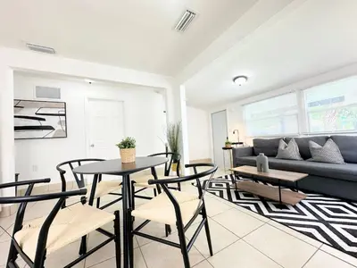 a living room with a couch and a table and chairs at Modern Miami Family Cottage Beach 15 min in Miami
