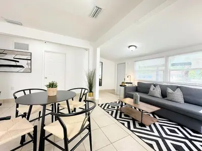 a living room with a blue couch and a table at Modern Miami Family Cottage Beach 15 min in Miami