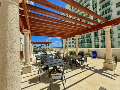 a patio with tables and chairs on a building at Elegant Centric Vibrant Pool Jacuzzi Free Parking in Miami