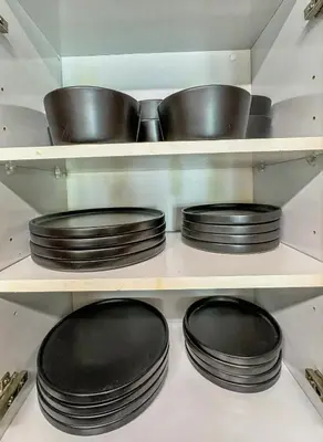 four black plates and pans on shelves in a kitchen at Elegant Centric Vibrant Pool Jacuzzi Free Parking in Miami