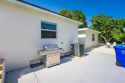 a barbecue grill in front of a white house at Modern Oasis Unit 2 - Close to Beach, Brickell & Airport in Miami