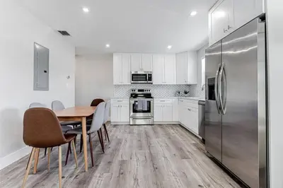 a kitchen with a table and a stainless steel refrigerator at Modern Oasis Unit 2 - Close to Beach, Brickell & Airport in Miami