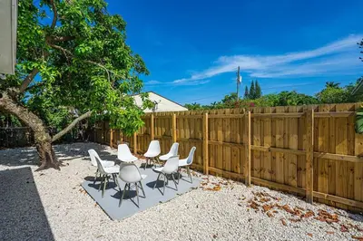 a group of white chairs and a fence at Modern Miami Unit 1 - Close to South Beach & Airport in Miami