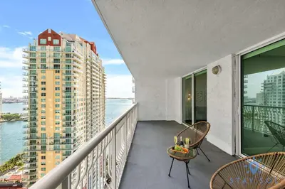 a balcony with chairs and a view of the water at Beautiful 1BR Apartment with Amenities in Miami