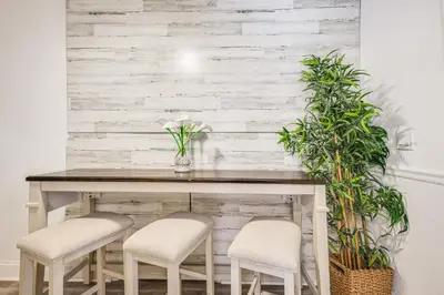 a dining room table with two stools and a table with plants at Hollywood Hideaway Close to Dtwn and Beaches in Hollywood
