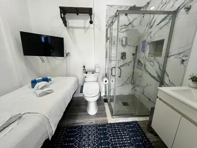 a bathroom with a shower and a toilet and a sink at POOLSIDE MANOR - Men Only Clothing-Optional in Fort Lauderdale