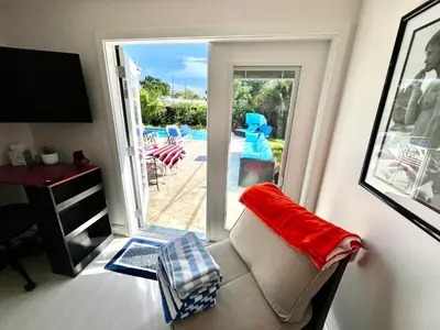 a living room with a couch and a sliding glass door at POOLSIDE MANOR - Men Only Clothing-Optional in Fort Lauderdale