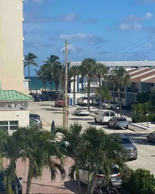 a parking lot with parked cars and palm trees at Hollywood Townhouse steps to beach and famous Broadwalk in Hollywood Beach