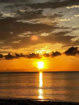 a sunset over the ocean with the sun setting at Hollywood Townhouse steps to beach and famous Broadwalk in Hollywood Beach
