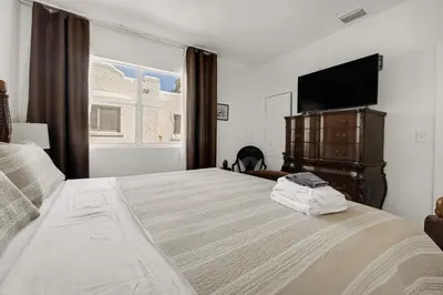 a bedroom with a bed with a flat screen tv at Private Rooms at Miami, Buena Vista with Parking in Miami