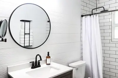 a white bathroom with a sink and a mirror at Melrose Villa in Miami