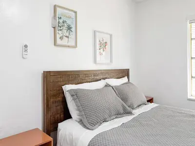 a bedroom with a bed and two pictures on the wall at Melrose Villa in Miami