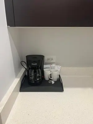 a coffee maker and two cups on a black tray at Doral Pool 310 by WaveProperties in Miami