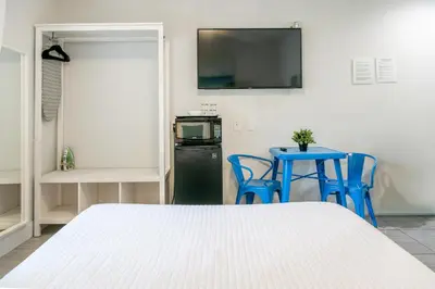 a room with a bed and a table and a television at 7130 Costa Boutique in Miami Beach