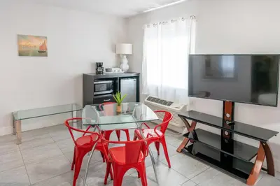 a living room with a table and red chairs at 7130 Costa Boutique in Miami Beach