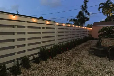 a fence with lights on it with a bench at CasaBay 4 Bed 2 Bath House Ultimate Backyard Fun in Cutler Bay