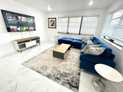 a living room with a blue couch and a table at Miami Oasis Near Beach in North Miami