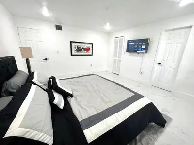 a bedroom with a bed and a tv on the wall at Miami Oasis Near Beach in North Miami