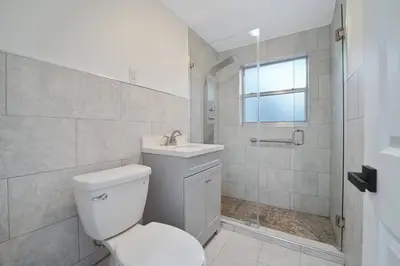 a bathroom with a toilet and a sink and a shower at Miami Oasis Near Beach in North Miami