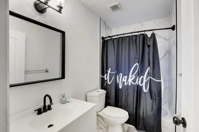 a bathroom with a toilet and a shower curtain at 8BR-4BA Spacious House, Sleeps 20, Pool, Fenced Yd in Miami