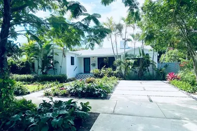 a white house with palm trees and a driveway at Experience Miami Magic: Tropical Pool Escape in Miami