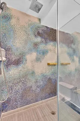 a bathroom with a shower with a mosaic wall at 1100 West South Beach Lux Waterfront Studio in Miami Beach