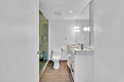 a bathroom with a toilet and a sink and a mirror at 1100 West South Beach Lux Waterfront Studio in Miami Beach