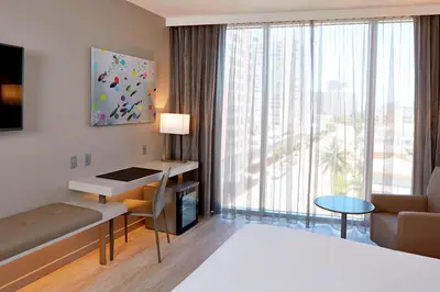 a living room with a large window and a room at AC Hotel by Marriott Miami Beach in Miami Beach