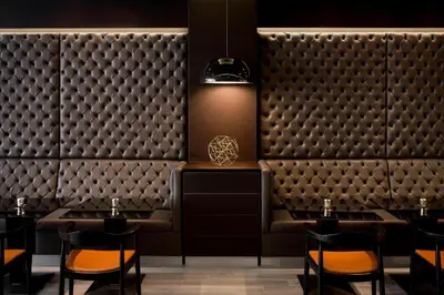 a restaurant with tables and chairs in front of a wall ofjectedjectedjectedjected at AC Hotel by Marriott Miami Beach in Miami Beach