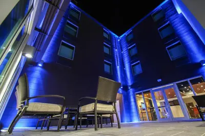 a group of chairs sitting in front of a building at Holiday Inn Express & Suites Miami Airport East by IHG in Miami