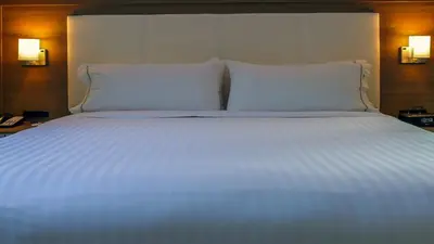 a large bed with white sheets and pillows at Holiday Inn Express & Suites Miami Airport East by IHG in Miami