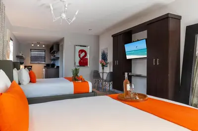 a bedroom with two beds and a flat screen tv at Seaside All Suites Hotel in Miami Beach