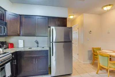 a kitchen with a stainless steel refrigerator and a table at Centrally Located Hallandale Beach Condo in Hallandale Beach