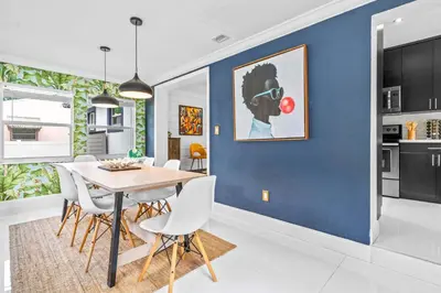 a dining room with a blue wall and a table and chairs at ArtHaus- Fully Stocked Kitchen and Fenced Yard in Miami