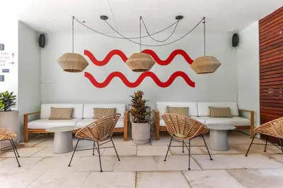 a room with chairs and tables and a painting on the wall at The Daydrift in Miami Beach