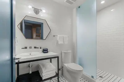a white bathroom with a toilet and a sink at The Daydrift in Miami Beach