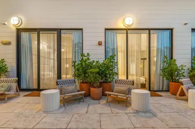 a patio with chairs and tables and potted plants at The Daydrift in Miami Beach