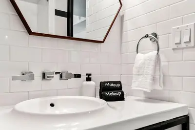 a white bathroom with a sink and a mirror at The Daydrift in Miami Beach