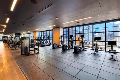 a gym with tread machines and people exercising in it at Ultimate Elegance Studio with Panoramic City Views in Miami