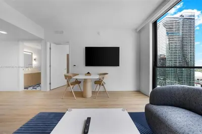 a living room with a tv and a couch and a table at 2 bedroom Condo at Gale Downtown Pool Gym SPA in Miami