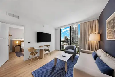 a living room with a couch and a large window at 2 bedroom Condo at Gale Downtown Pool Gym SPA in Miami