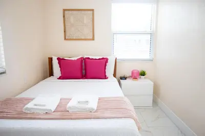 a bedroom with a large bed with pink pillows at Central Getaway in Little Havana Near Airport, Wynwood, Calle 8 Brickell, Coral Gables and more , Fenced parking in Miami