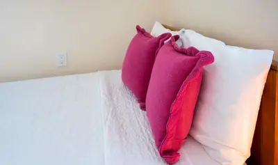 two pillows sitting on top of a bed at Central Getaway in Little Havana Near Airport, Wynwood, Calle 8 Brickell, Coral Gables and more , Fenced parking in Miami