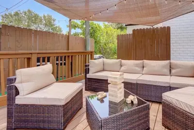 a patio with wicker furniture and an umbrella at Most Unique Space in Fort Lauderdale