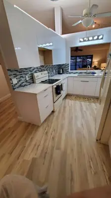 a kitchen with white cabinets and a wooden floor at Beach Lake Paradise - Super Location! in Fort Lauderdale