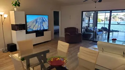 a living room with a television and a table and chairs at Beach Lake Paradise - Super Location! in Fort Lauderdale