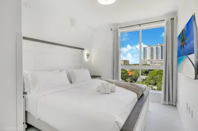 a white bedroom with a large white bed and a window at Lux 3BR City-View Retreat in Hollywood, 3rd Floor in Hollywood