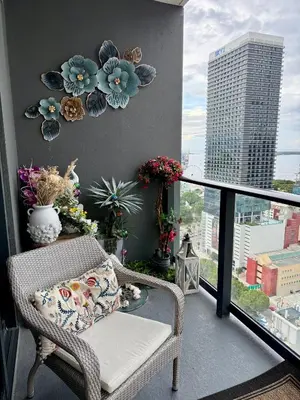 a balcony with a wicker chair and a view of a city at Miami Luxury 27th Floor, Best Waterfront Balcony View & City Lights, Pool,Gym,Spa in Miami