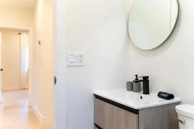 a bathroom with a sink and a mirror on the wall at Casa Siesta- Hot tub Home Gym and Modern Design in Miami